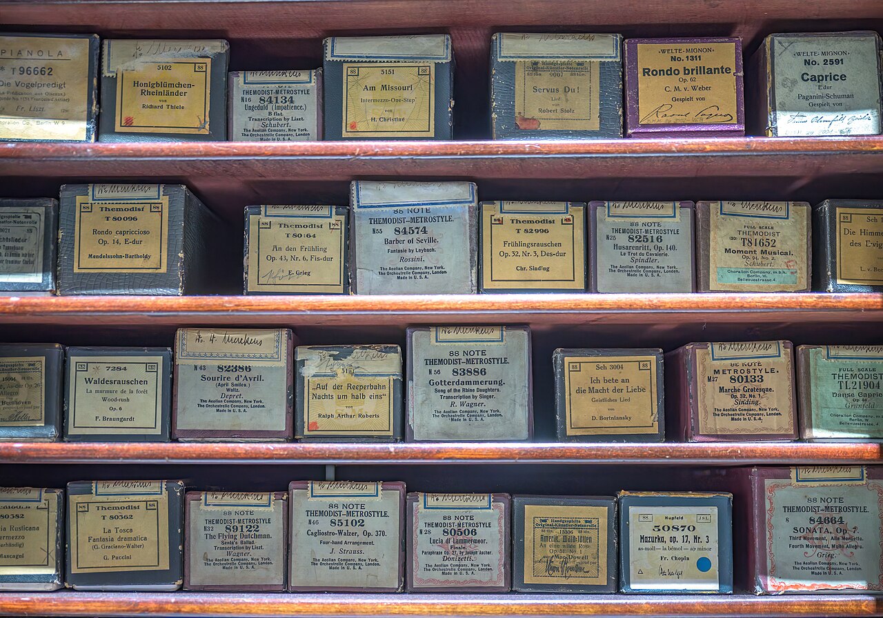 Wooden shelves of long, flat archive boxes stored in tight rows, standing in for folders full of old files